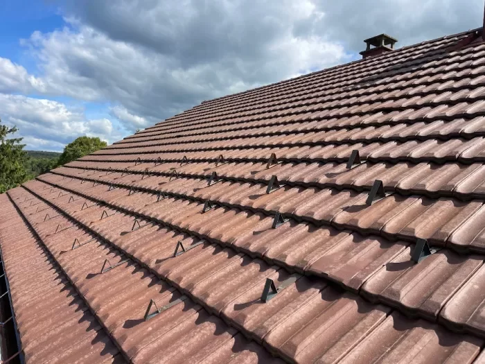 Artisan couvreur réalisant l'entretien d'une toiture à Lons-le-Saunier